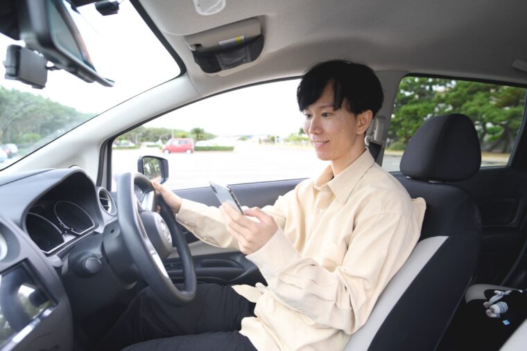 車内でスマホを確認するドライバー