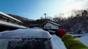 雪が積もった車の除雪作業