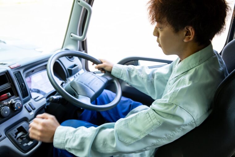 トラック運転席で運転するドライバー