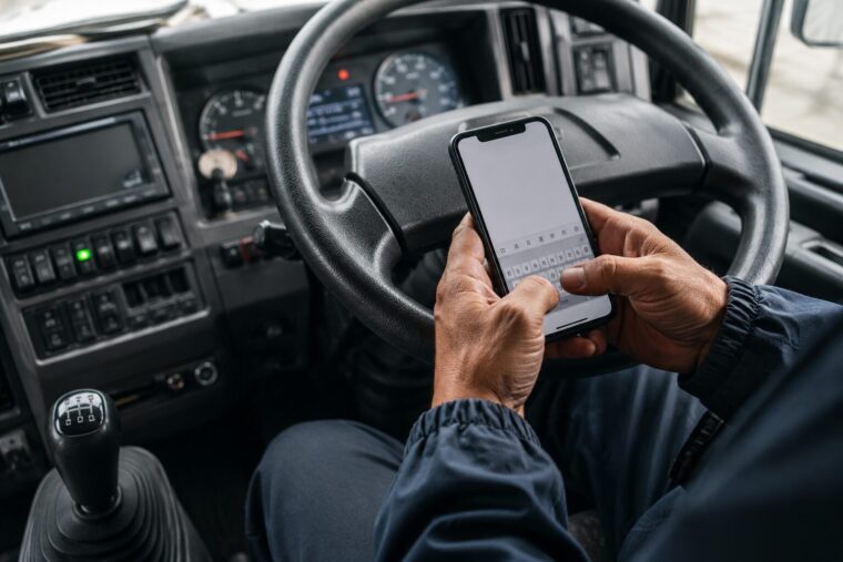 運転席でスマホで記録するドライバー
